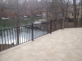 Travertine Tile stone deck with iron rail by Archadeck of Charlotte